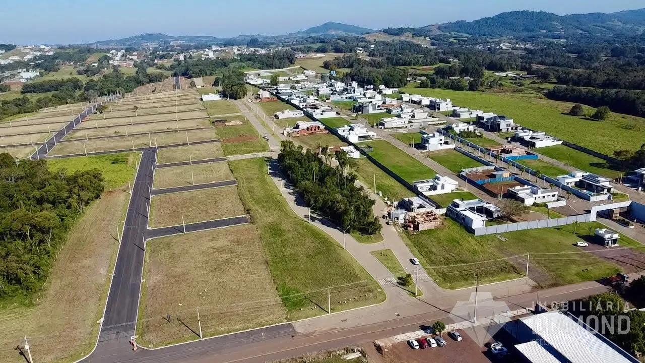 Vista aérea de uma propriedade rural com campos e construções dispersas na paisagem.