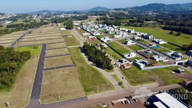 Vista aérea de uma propriedade rural com campos e construções dispersas na paisagem.