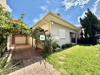Fachada de uma casa em Lajeado, Brasil, com jardim gramado e garagem.