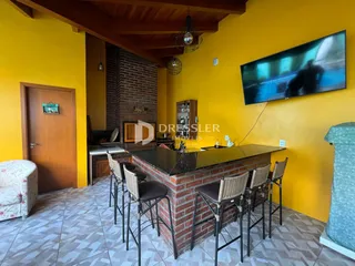 Sala de estar com paredes amarelas e parede de tijolos expostos.