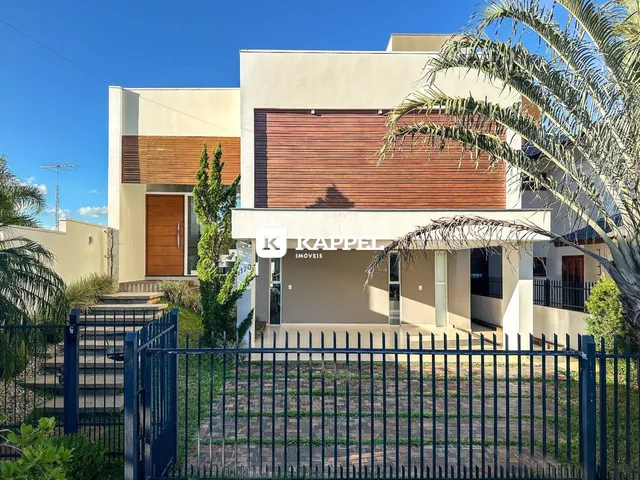 Foto da fachada de uma casa moderna em Lajeado, Brasil, com jardim e cerca.
