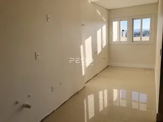Interior de um cômodo com paredes brancas e piso de cerâmica.