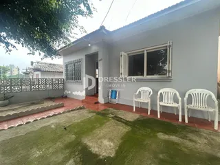 Vista externa de uma casa em Lajeado, Brasil, com jardim gramado e muro de divisa.