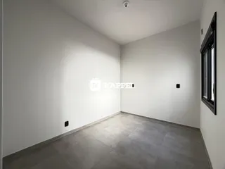 Vista interna de um cômodo com paredes brancas e piso de porcelanato cinza.