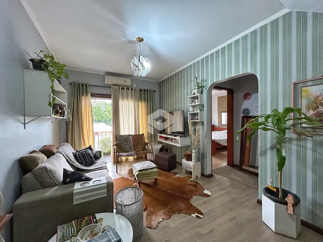 Sala de estar com sofá e piso de madeira em um imóvel no Brasil.
