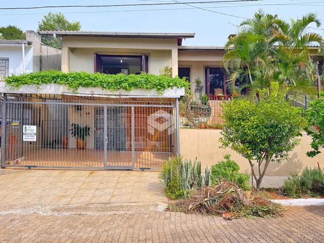 Vista da fachada de uma residência em Lajeado, Brasil, com cerca e jardim na frente.