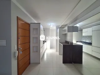 Hall de entrada com armários brancos e piso claro em um imóvel em Lajeado.