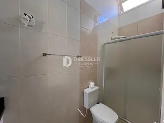 Foto de um banheiro com revestimento cerâmico e vaso sanitário.