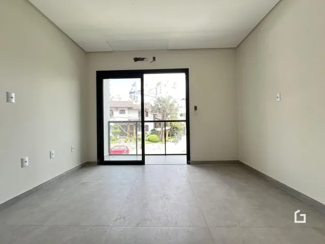 Interior de um cômodo com paredes brancas e piso de concreto.