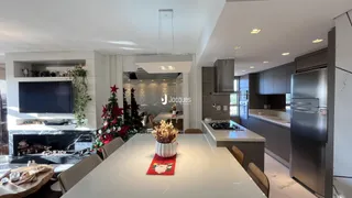 Uma cozinha moderna com ilha central e lareira em um imóvel.