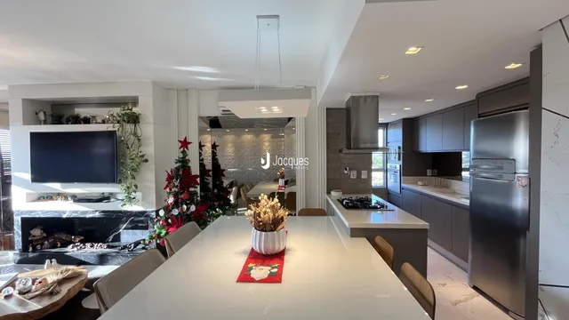 Uma cozinha moderna com ilha central e lareira em um imóvel.