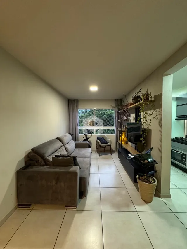 Sala de estar com sofá e piso de cerâmica em um imóvel no Brasil.