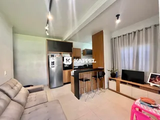 Sala de estar com sofá e área de cozinha moderna.