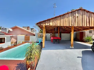 Vista externa de uma propriedade com piscina e deck.