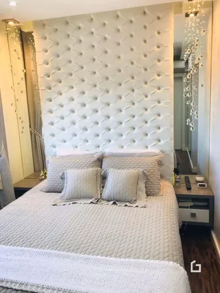 Foto de um quarto com cabeceira acolchoada branca.