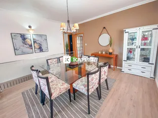 Foto de uma sala de jantar com mesa de vidro e cadeiras em um ambiente interno.
