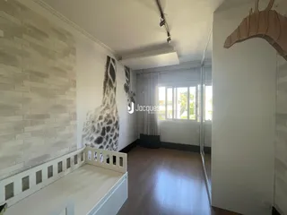 Quarto com parede de tijolos e piso de madeira clara em um imóvel no Brasil.