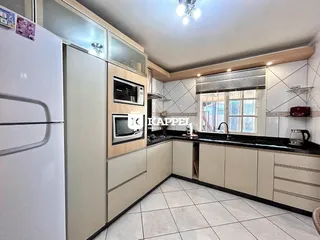 Cozinha moderna com armários brancos e piso de cerâmica.