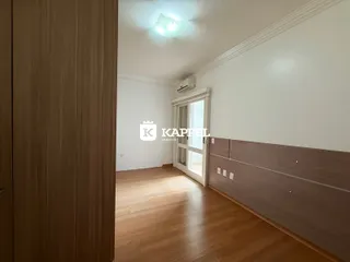 Ambiente interno com piso de madeira e painéis de madeira na parede.