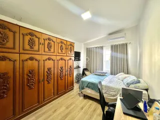 Quarto com armário de madeira e cama em um ambiente interno.