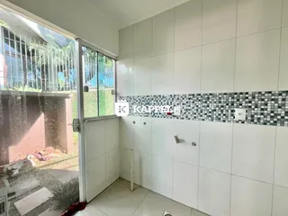 Foto de um cômodo interno com revestimento de azulejos e vista para o exterior.