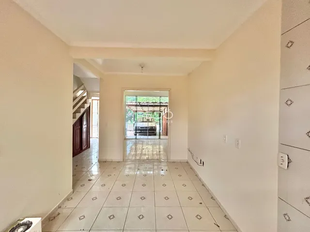 Corredor interno de uma residência com piso de cerâmica.