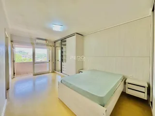 Quarto com janela e armário branco.
