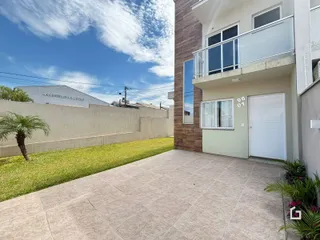 Fachada de uma residência em Lajeado, Brasil, com jardim e área pavimentada.