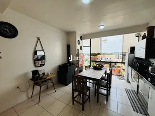 Ambiente interno com mesa de jantar e vista para o exterior.