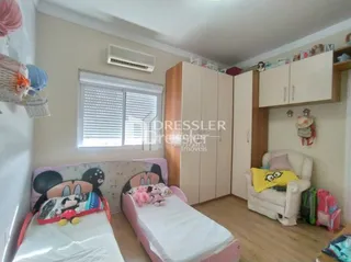 Quarto com duas camas e armários em madeira.
