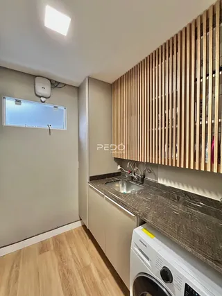 Vista de uma cozinha moderna com armários e piso de madeira clara.
