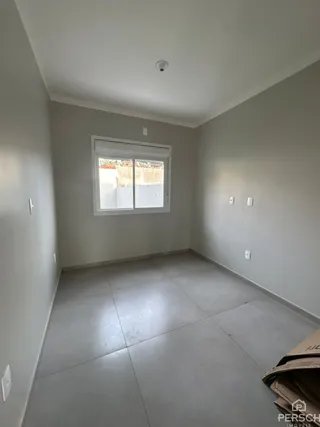 Ambiente interno de um cômodo com paredes claras e piso de porcelanato.