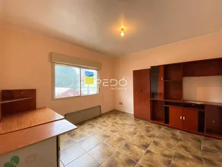 Sala de estar com piso de cerâmica e móveis de madeira em um imóvel no Brasil.