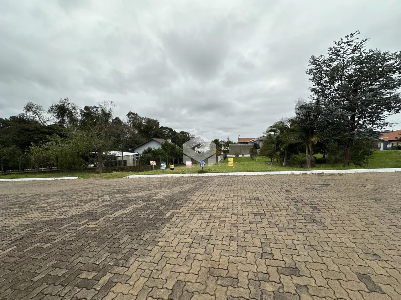Vista externa de uma propriedade com vegetação ao fundo.