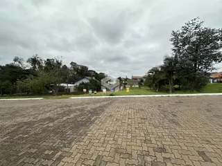 Vista externa de uma propriedade com vegetação ao fundo.