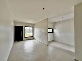 Ambiente interno de uma sala com piso de cerâmica e paredes brancas.