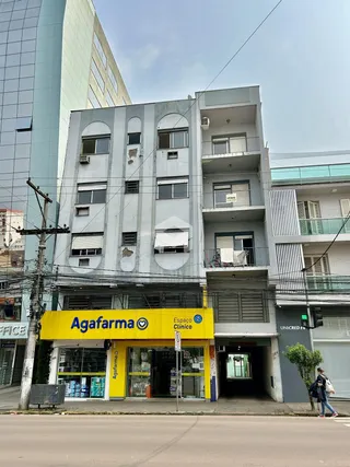 Fachada de um prédio residencial em Lajeado, Brasil, com comércio no térreo.