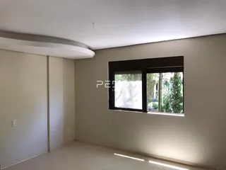 Vista interna de um ambiente com parede lisa e janela.