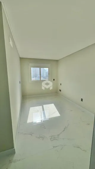 Corredor interno com piso de mármore claro e paredes brancas.