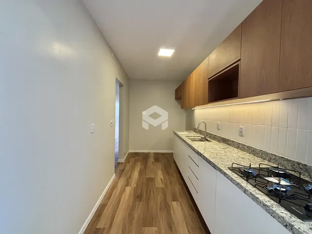Foto de uma cozinha moderna com armários brancos e piso de madeira clara.
