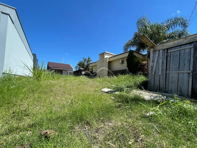 Vista externa de uma propriedade com gramado verde e vegetação ao ar livre.