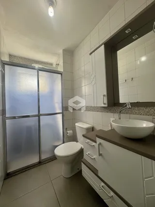 Banheiro com piso cerâmico e bancada de madeira.