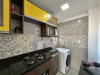 Foto de uma cozinha com revestimento cerâmico e armários de madeira.
