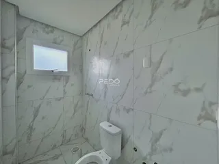 Foto de um banheiro com revestimento de azulejos brancos.