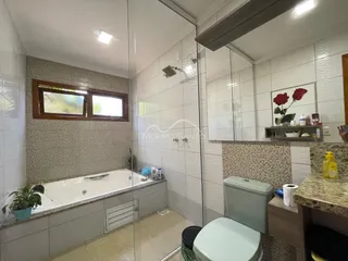 Banheiro com banheira e revestimento de azulejos brancos.