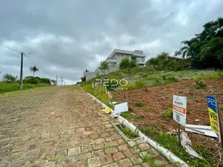A fachada de uma residência em Lajeado, Brasil, vista ao longo de uma estrada de terra.