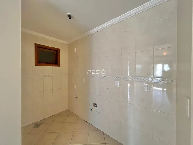 Corredor interno com piso e paredes revestidos de cerâmica branca.
