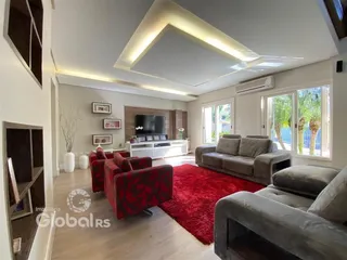 Sala de estar com piso de madeira e sofá cinza.