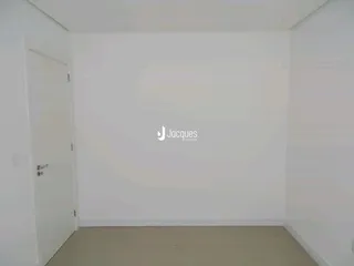 Foto de um cômodo interno vazio com paredes brancas.