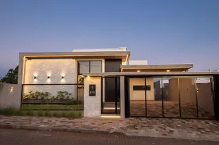 Fachada externa de uma casa moderna em Lajeado, Brasil, com iluminação noturna.